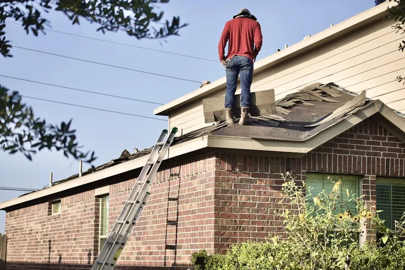 Professional roofer working on a residential roof in Slater